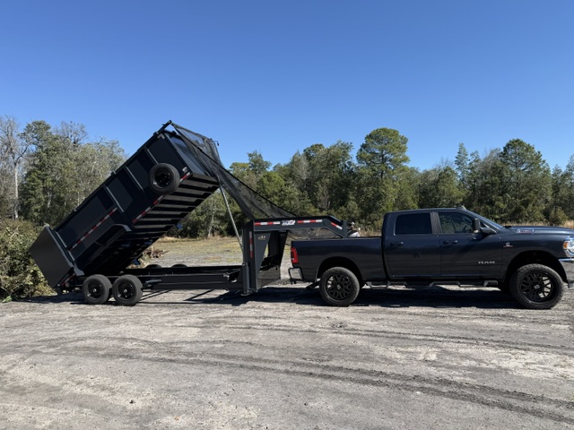 AGES Tree Service RAM truck with dump trailer unloading debris at disposal site in Orange Park FL